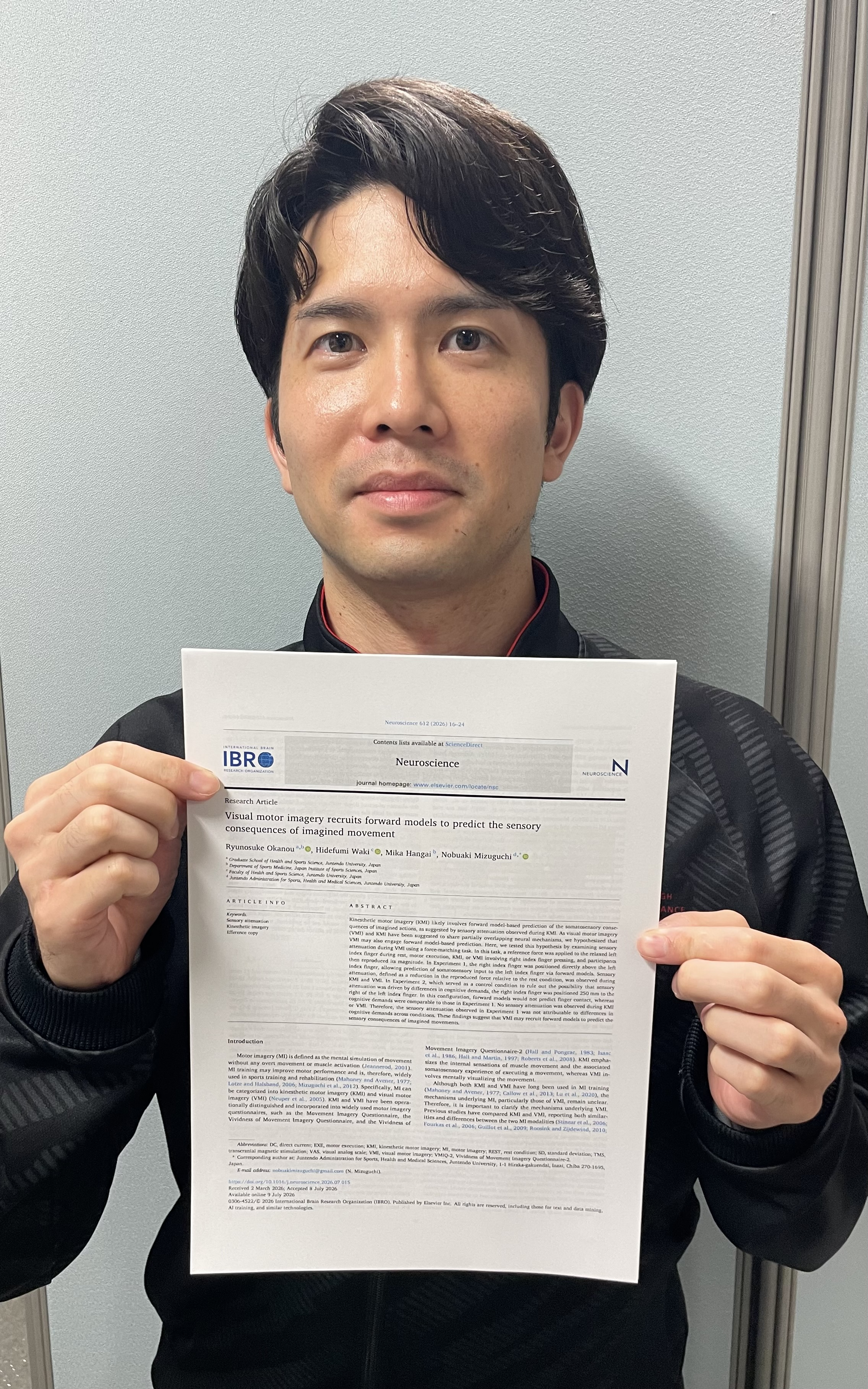論文を手にする岡納竜之介さん